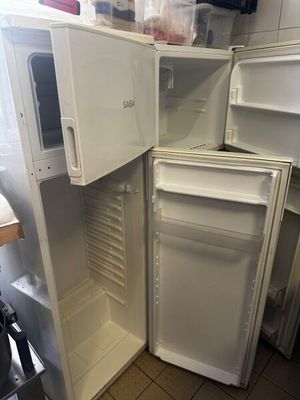 un réfrigérateur blanc dont la porte est ouverte, dans une cuisine