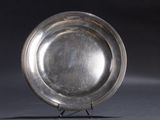 a silver plate on a stand on a black background