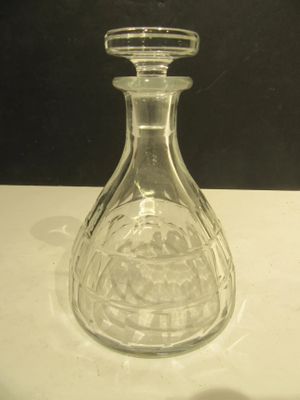 une bouteille en verre transparent avec un bouchon, posée sur une table