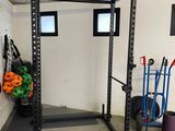 an image of a gym room with a barbell rack and other equipment