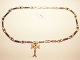 a gold chain with a cross on it on a table