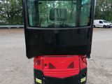 a small red and black vehicle parked in a parking lot