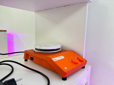 une petite machine orange posée sur un comptoir blanc