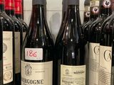Des bouteilles de vin rouge sont alignées sur une étagère dans un magasin