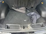 the trunk of a car with a bag and umbrella in the trunk