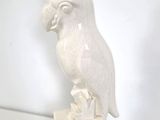 a white sculpture of a bird sitting on top of a box