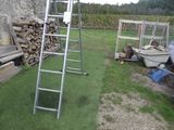 une échelle posée dans l'herbe à côté d'un tas de bois