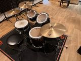 a drum set that is sitting on a rug in a room
