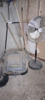 a fan sitting next to a chair in a room