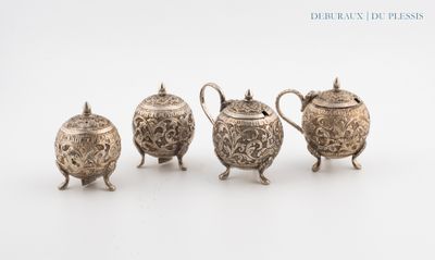 three silver teapots and a sugar bowl on a white surface