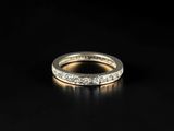 a white gold wedding ring with diamonds on a black background