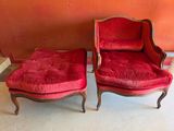 deux chaises rouges et un repose-pieds devant un mur orange
