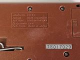 a close up of a brown electronic device on a white surface