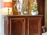 une photo d'un salon avec une statue posée sur le buffet
