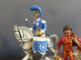 three figurines of a man riding a horse and a man riding a horse