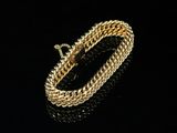 a gold bracelet on a black surface