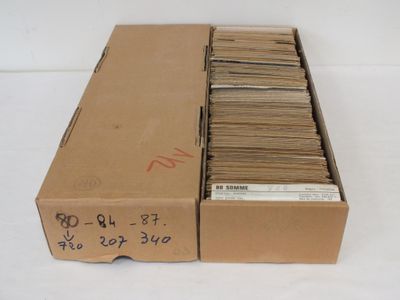 une boîte en carton ouverte, remplie d'une multitude de papiers, posée sur une table