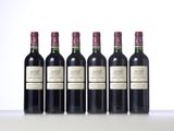 four bottles of wine are lined up on a table