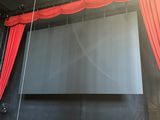 a stage with a red curtain and a large screen