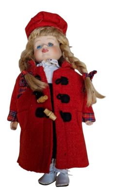 poupée vêtue d'un manteau rouge et d'un chapeau, aux longs cheveux blonds et aux yeux bleus