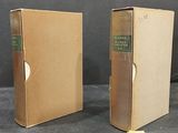 pair of two old books in cardboard boxes on a table