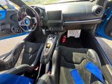 l'intérieur d'une voiture de sport bleue, avec le volant et le tableau de bord