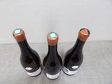 three bottles of wine sitting on top of a table next to each other
