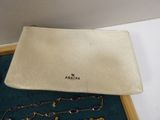 an image of a white purse with a necklace and bracelet on it
