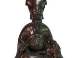 a statue of a man sitting on the ground with a bowl on his head