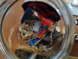 a glass jar filled with various items on a table