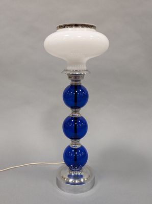 a close up of a blue and white lamp on a table