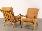 pair of rattan lounge chairs with upholstered cushions