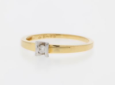 a gold and diamond ring with a single stone in the middle