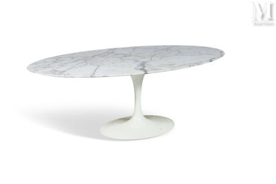 une table à manger ovale en marbre avec un piètement blanc