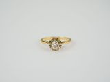 a yellow gold ring with a diamond in the center