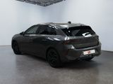 the rear end of a gray car in a white room