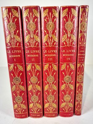 cinq livres rouges ornés de motifs dorés, posés sur une surface blanche