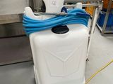 un récipient blanc auquel est raccordé un tuyau bleu