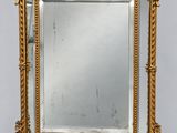 un miroir à cadre doré orné d'un motif décoratif sur le pourtour