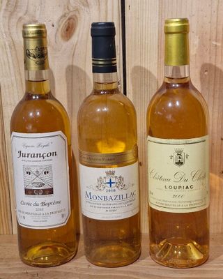 three bottles of wine are lined up on a wooden table
