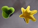 two yellow and green bowls sitting on a table