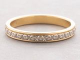 a close up of a gold wedding ring on a gray surface