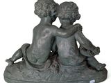 a statue of two children that are sitting on a rock