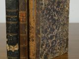 deux vieux livres posés l'un à côté de l'autre sur une table en bois