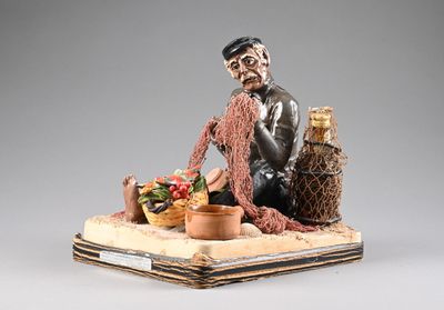 figurine représentant un homme assis sur une table avec une corbeille de fruits