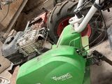 une moto verte et blanche garée dans un garage