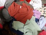 a pile of clothes sitting on top of a bed