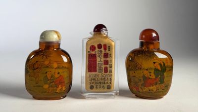trois bouteilles en verre aux motifs différents, posées les unes à côté des autres