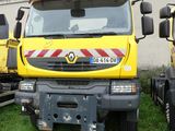 two yellow trucks parked next to each other in the grass