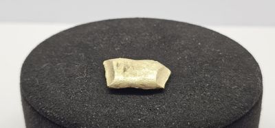 gros plan d'une bague en or sur une surface noire